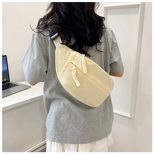 Détail du sac de poitrine en nylon beige avec tirette de fermeture éclair tissée