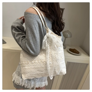 Close-up of intricate floral lace pattern and decorative bow on white beach tote bag