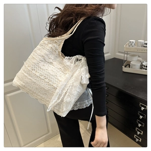 Detailed close-up of intricate lace textures and floral patterns on white tote bag