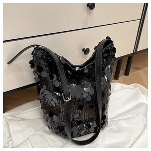 Dettaglio della borsa a secchiello nera con grandi paillettes e tracolla in pelle