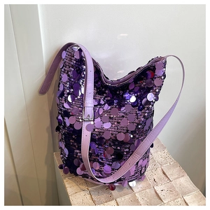 Dettaglio borsa a secchiello con paillettes viola e tracolla su base in pietra moderna