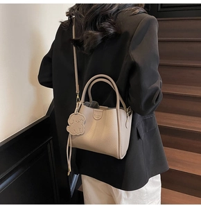 Litchi pattern leather bucket bag in elephant grey with a cute dog pendant and strap