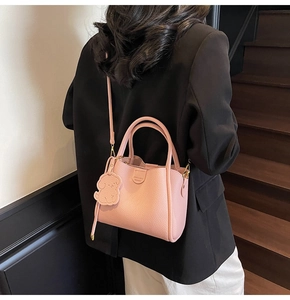 Detail of pink lychee grain handbag with matching puppy charm and brand embossing