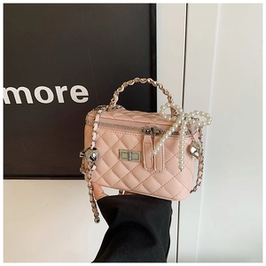 Detail van roze gewatteerde mini box tas met parelstrikl en zilveren kettingriem