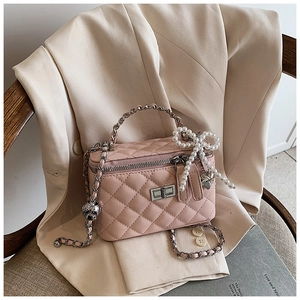 Detail van roze gewatteerde vanity case met zilveren draaislot en parelmoer hanger