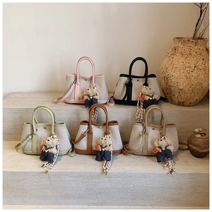 Detailed arrangement of canvas bucket bags with leather trim and teddy bear pendants