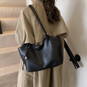 Minimalist large black tote bag in matte faux leather with elegant woven rope pendant