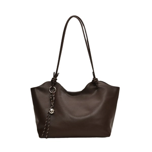 Dark brown tote bag with wavy rim design and metallic charm detail on white background