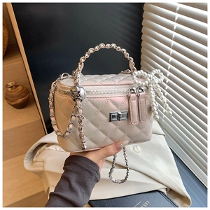Detail van parelmoer gewatteerde box bag met parelmoer strik en ketting handvat