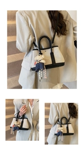 Detail view of canvas bucket bag with black leather trim and cute bear charm accessory