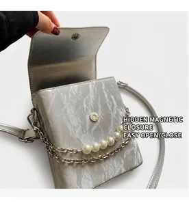 Détail du sac argenté avec fermeture magnétique invisible et chaîne en perles