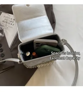 Vue intérieure d'un sac argenté montrant l'espace pour deux smartphones et un rouge à lèvres