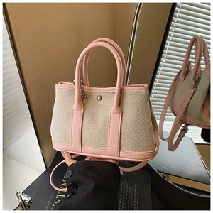 Detail of canvas and pink leather tote bag with silver button and mirror reflection