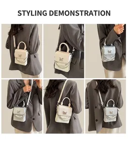 Détails du sac argenté avec fermoir papillon en métal et ornements en perles blanches