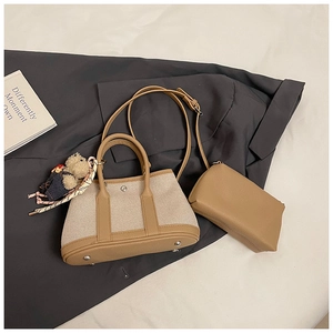 Detail of canvas tote bag with brown leather trim, matching pouch and cute bear charm