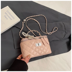 Detail van lichtroze gewatteerde mini-tas met hartbedel en parelketting schouderriem