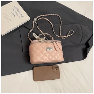 Detail van roze gewatteerde boxtas met zilveren ketting en parel hartvormige hanger