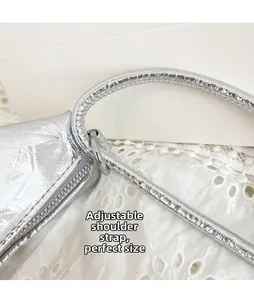 Detail of adjustable strap and silver metallic texture on the minimalist shoulder bag