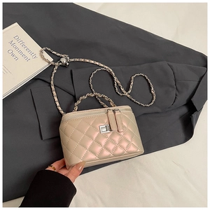 Detailweergave van de parelroze gewatteerde box-tas met zilveren ketting en slot