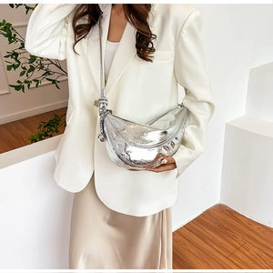 Close-up of metallic silver crescent bag with ruched texture and stylish knot detail