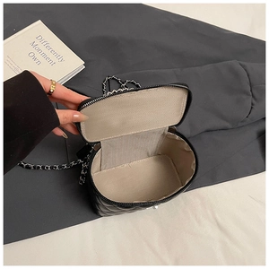 Detailopname van de gewatteerde crossbodytas binnenkant met ketting op een strakke achtergrond