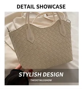 Gros plan d'un sac cabas tressé beige montrant le motif damier et les détails métalliques