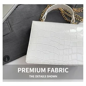 Detailed close-up of white crocodile embossed leather and gold metal chain strap on handbag