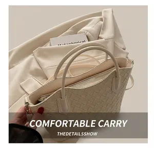 Détail d'un sac en cuir tressé beige avec doubles poignées et fermeture éclair argentée