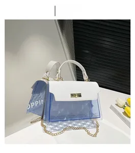 Detail of blue quilted translucent handbag with white croc-textured flap and gold lock