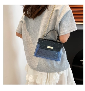 Detail of blue quilted PVC handbag with black croc-texture leather and gold chain strap