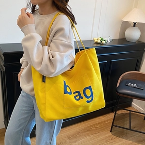 Fashionable bright yellow canvas tote bag with blue bag lettering and outer pocket