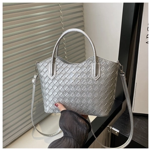 Détail du sac cabas tressé argenté avec bandoulière et texture métallique intense