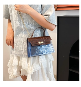 Detail of blue transparent PVC crossbody bag with brown croc-embossed leather flap