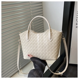 Détail du sac cabas beige en cuir tressé avec poignées et bandoulière amovible