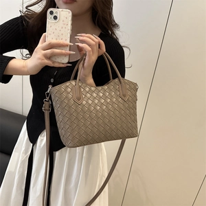 Sac à main tressé marron avec bandoulière réglable présenté dans un décor intérieur