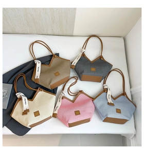 Detailed view of multiple color woven tote bags with leather straps and ribbons