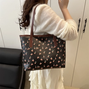 Large black tote bag with cherry print and brown shoulder straps for women's daily commute