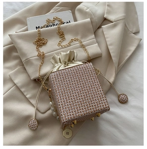 Detail der FF-Print Beuteltasche mit Goldkette, Perlenanhänger und Bodennägeln am Boden