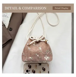Detail view of woven bucket bag featuring white floral embroidery and cotton rope strap