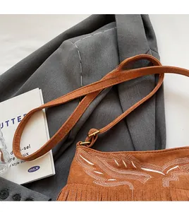 Détail du sac seau en daim marron avec broderie ethnique et longues pampilles à franges
