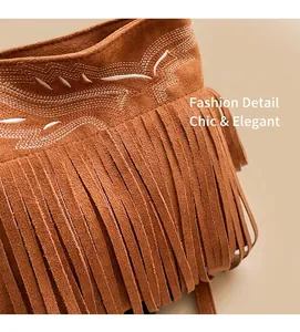 Gros plan du sac seau en daim marron avec des franges bohèmes et une broderie ondulée blanche
