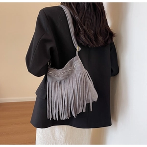 Détail du sac seau gris dépoli avec franges bohèmes et broderies élégantes en gros plan
