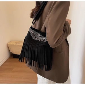 Détail du sac seau noir en daim avec broderie plume à paillettes et longues franges