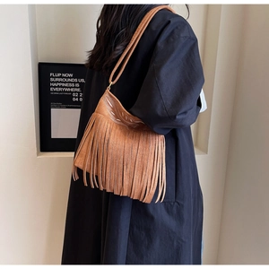 Détail du sac seau en daim marron avec broderie blanche et franges bohèmes