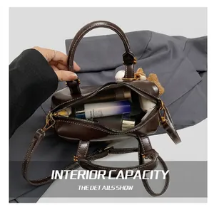 Detail view of small dark brown Boston bag showing inner capacity and luxury leather texture