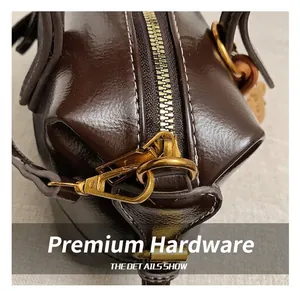 Macro view of vintage brown leather bag showing bronze hardware and precise stitching