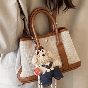 Chic canvas and brown leather tote bag with a cute teddy bear charm for women