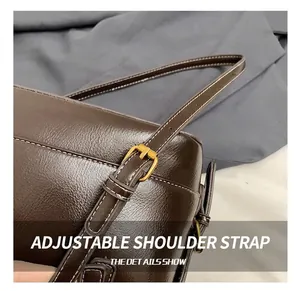 Detail of adjustable leather strap with gold buckle and white contrast stitching