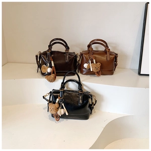 Detail of vintage Boston handbags in three colors with cute bear and baseball charms