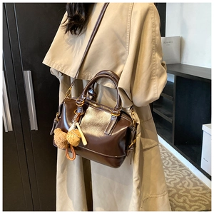 Detailed view of vintage dark brown faux leather Boston bag with plush bear charm